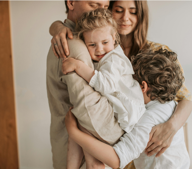 Familia de padres e hijos abrazándose.