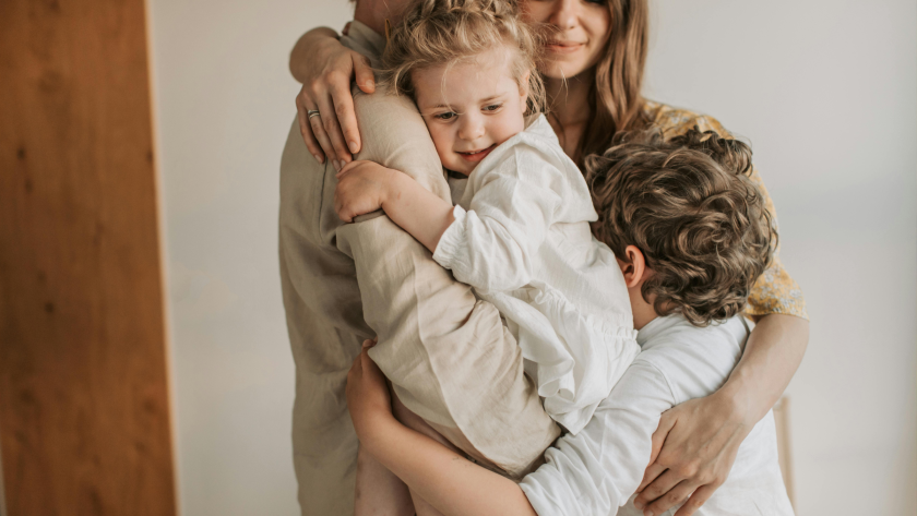 Familia de padres e hijos abrazándose.
